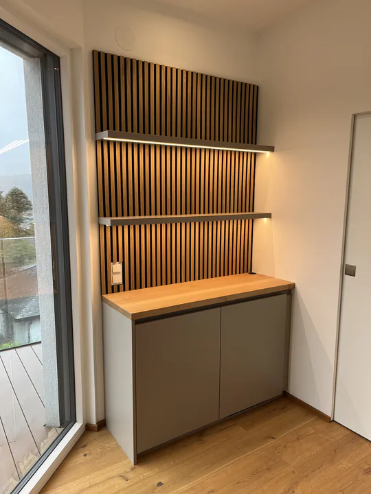 Kaffeebar-Nische mit Akustik-Lamellenwand, Ablage aus Eiche und schwebenden Fachböden
