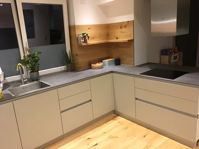 Sanierte Küche mit neuer Arbeitsplatte in Betonoptik und neuem Kochfeld