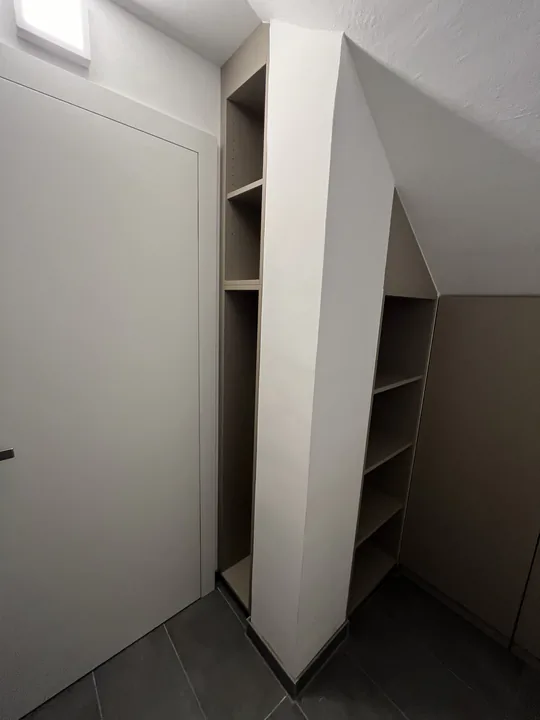 Begehbarer Eckschrank mit offenen Fachböden in einem Nebenraum