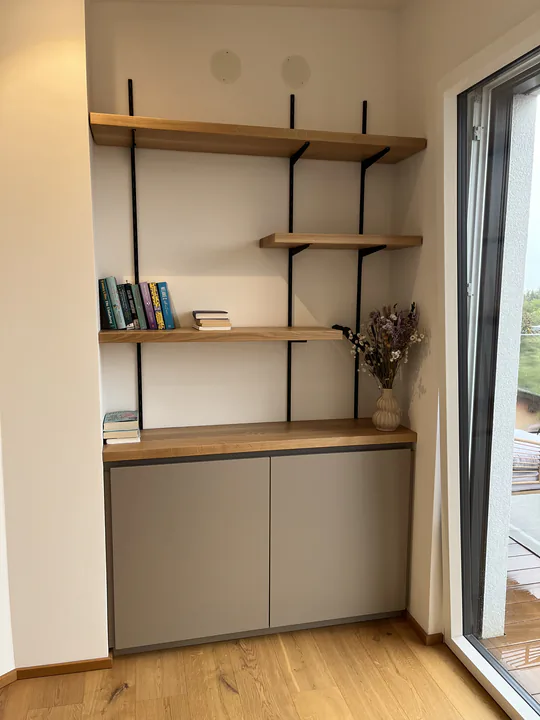 Wandregal mit Eichenböden auf schwarzen Stahlträgern über einem Sideboard